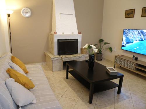 a living room with a couch and a tv at Sette Isole Countryside Retreat Near Egremni Beach in Athanion