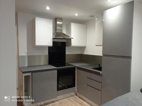 a kitchen with stainless steel appliances and white cabinets at AppartHôtel in Poitiers