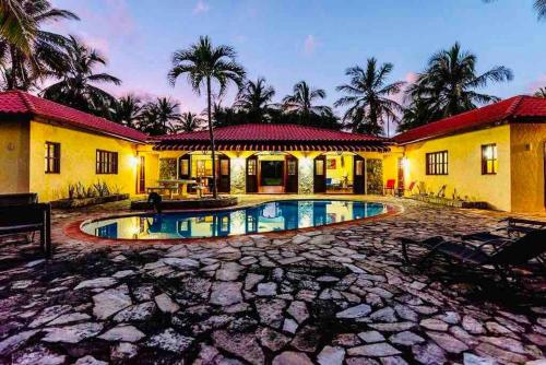 una casa con piscina frente a ella en PALM HOUSE - LUXURY VILLA - SAMANÁ - Ocean Front en Sánchez