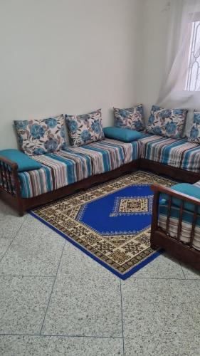 um sofá sentado numa sala de estar com um tapete em appartement centre kenitra em Kenitra