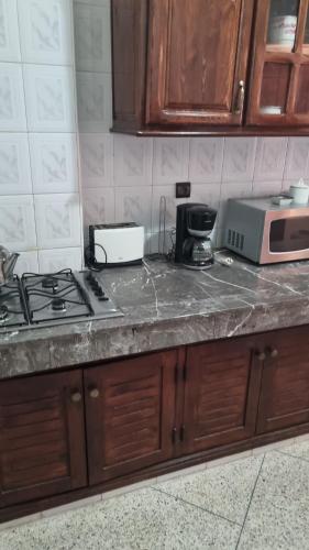 um balcão de cozinha com um fogão e um micro-ondas em appartement centre kenitra em Kenitra