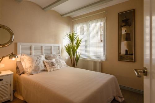 a bedroom with a bed and a window and a plant at Apartamento Marina in Lloret de Mar