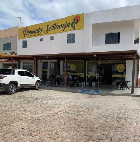 a white car parked in front of a building at Pousada Sertaneja in Canindé de São Francisco