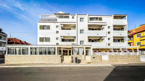 un grand bâtiment blanc sur le côté d'une rue dans l'établissement Branco Suites - Rooms & Holiday Apartments, à Santa Maria