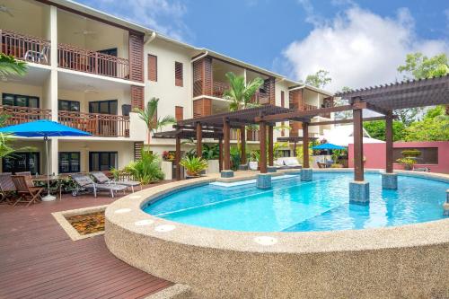 a swimming pool in front of a hotel at Seascape Holidays at 30 Tropic Style in Port Douglas