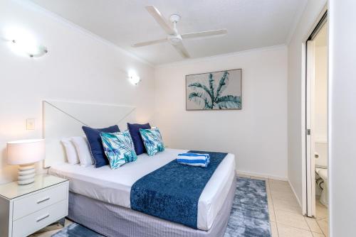 a bedroom with a bed and a ceiling fan at Seascape Holidays at 30 Tropic Style in Port Douglas