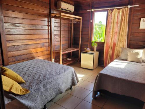 a bedroom with a bed and a window at Namorada Brava Guest House in Búzios