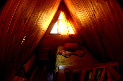 a small bedroom with a small bed in a room with a window at Cabana hotel eco turistico el EDEN in Güicán