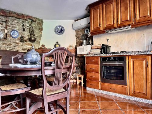 ブラガンサにあるCasa da Barriada Iのキッチン(木製キャビネット、テーブル、椅子付)