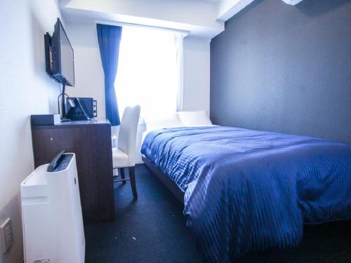 a bedroom with a blue bed and a window at HOTEL LiVEMAX Tokyo Shiomi Ekimae in Tokyo