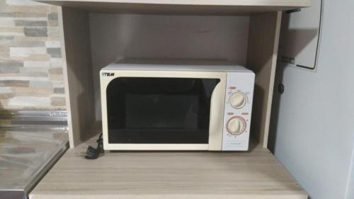 a microwave oven sitting on a shelf in a kitchen at La Baquiana in Mercedes