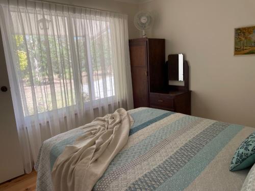 a bedroom with a bed with a window and a television at Veritas Cottage in Tanunda