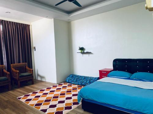a bedroom with a bed and a chair and a rug at Casa Drezqi Homestay Melaka Private Pool in Melaka
