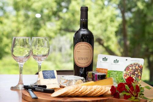 a bottle of wine and wine glasses on a table at Gan Eden Retreat-Byron bay , luxuries escape in Mullumbimby