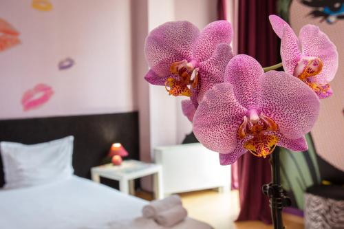 a vase of purple orchids in a bedroom at Art Hotel Simona in Sofia