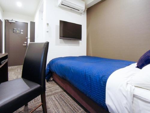 a hotel room with a bed and a television at HOTEL LiVEMAX Kakegawa-Ekimae in Kakegawa