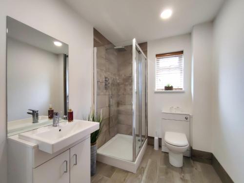 a bathroom with a sink and a shower and a toilet at Orchard View - 4-Bed Home In Kempsford, Cotswolds 