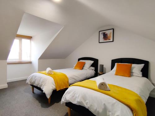 two beds sitting next to each other in a room at Orchard View - 4-Bed Home In Kempsford, Cotswolds 