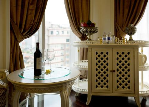 a room with a table with a bottle of wine at Eldora Hotel in Hue
