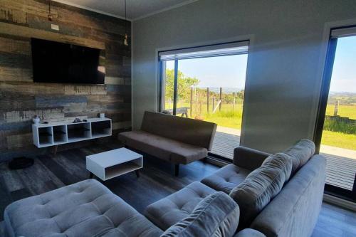 sala de estar con sofá y TV en Cabaña y Tinaja Pid -Pid Alto, Castro - Chiloé, en Castro