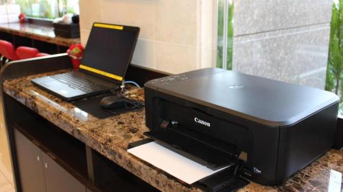a black printer and a laptop on a counter at Toyoko Inn Tokyo eki Shin ohashi Mae in Tokyo