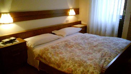 1 dormitorio con 1 cama grande y 2 almohadas en Campiglio Trilocale Monte Spinale, en Madonna di Campiglio