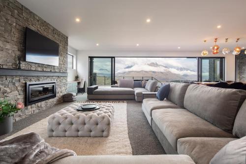a living room with a couch and a fireplace at Aroha on Florence by Sothebys Luxury Rental Homes in Queenstown