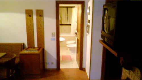 a room with a bathroom with a toilet and a doorway at Campiglio Bilocale Monte Spinale in Madonna di Campiglio