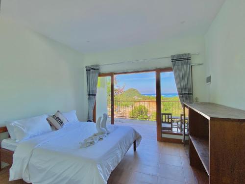 a bedroom with a bed and a balcony with a view at Ocean View Villas in Kuta Lombok
