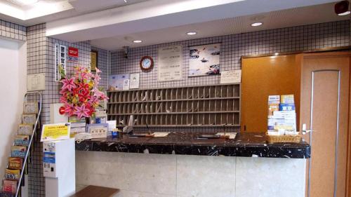 a kitchen with a counter and a clock on the wall at Toyoko Inn Tokyo Kamata No 1 in Tokyo