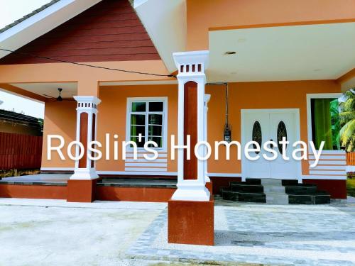 ein Haus mit einem Schild mit der Aufschrift „Rosellas Homestay“ in der Unterkunft Roslin's Homestay in Kota Bharu