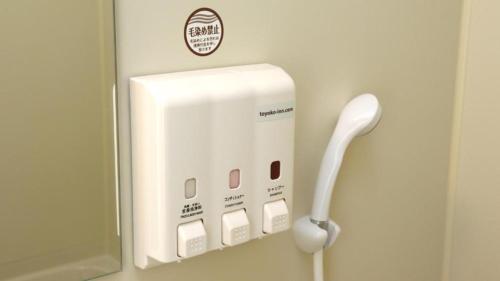 a white telephone hanging on a wall at Toyoko Inn Tokyo Haneda Airport No.2 in Tokyo