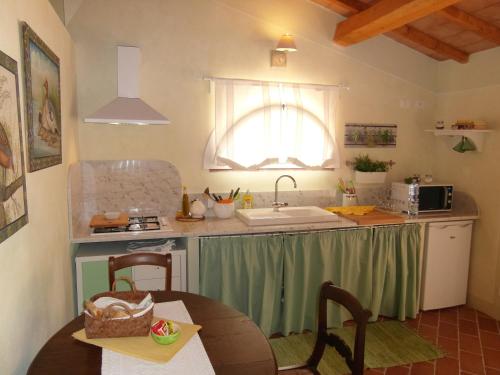 a kitchen with a table and a sink and a table and a window at Bed and breakfast Casa Formica in Cascina