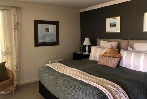 a bedroom with a large bed and a chair at KARANDA BnB in Rotorua