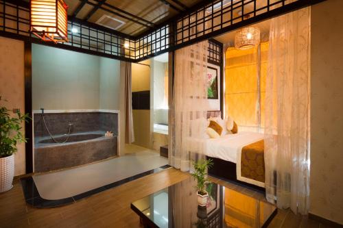 a bedroom with a tub and a bed and a bath room at Galina Hotel & Spa in Nha Trang