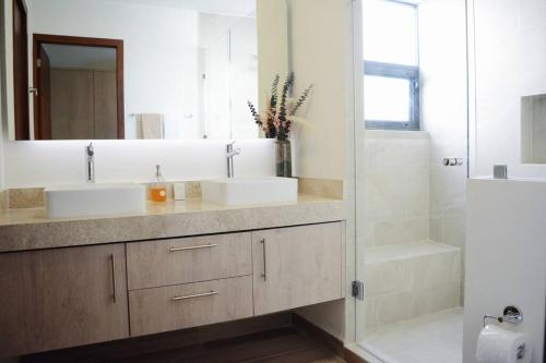 W łazience znajdują się 2 umywalki, lustro i prysznic. w obiekcie Amazing Dream Home in Gated Community w mieście Playa del Carmen
