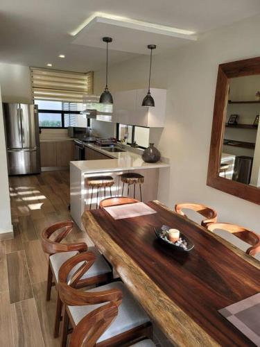 a kitchen and dining room with a wooden table and chairs at Amazing Dream Home in Gated Community in Playa del Carmen