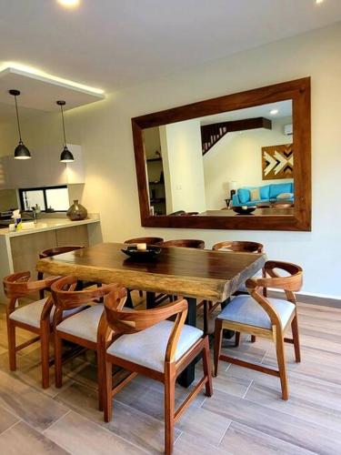 a dining room with a table and chairs and a mirror at Amazing Dream Home in Gated Community in Playa del Carmen