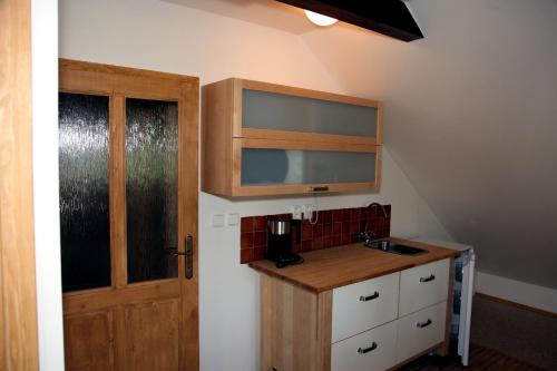 a kitchen with a sink and a wooden cabinet at Penzion Pod lesem in Pec pod Sněžkou