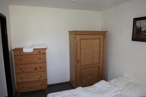 a bedroom with a wooden cabinet and a bed at Penzion Pod lesem in Pec pod Sněžkou