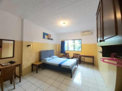 a bedroom with a bed and a table and chairs at Sentosa Hotel & Restaurant - tersertifikasi CHSE dari Kementerian Pariwisata dan Ekonomi Kreatif in Bekasi