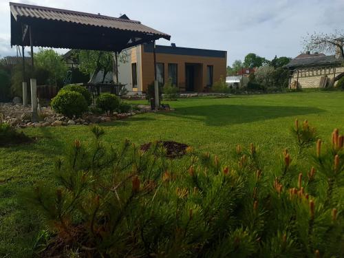 una casa en un patio con césped verde en Sipis House, en Šiauliai