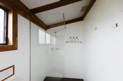 a bathroom with a shower with white walls at Palmers Lane Estate Hunter Valley in Pokolbin