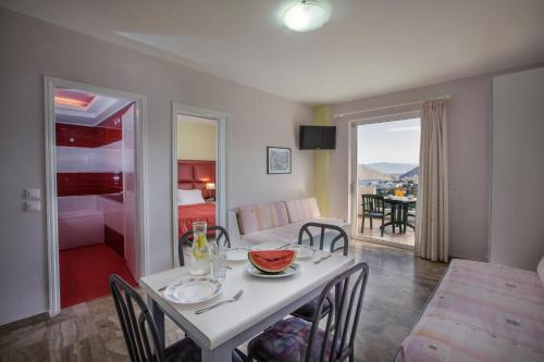 a dining room and living room with a table and chairs at Hotel Apartments Panorama in Tolo