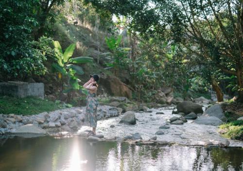 a woman standing in the water near a river at The Stream House in Ban Pok Nai