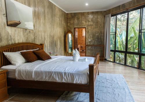 ein Schlafzimmer mit einem großen Bett und einem großen Fenster in der Unterkunft The Stream House in Ban Pok Nai