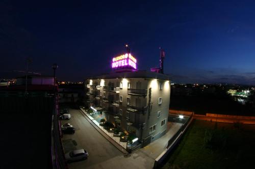 a building with a neon sign on top of it at Hotel Luxor in Casoria