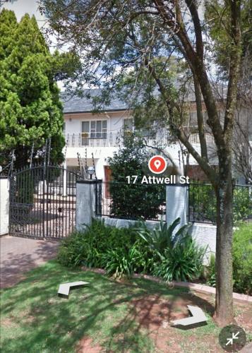 a sign in front of a gate in front of a house at CHIC Guest House & Solar system accommodations in Germiston