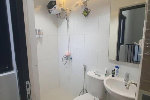 a bathroom with a toilet and a sink at Haidar SmartHome Grandwisata in Cibuntu