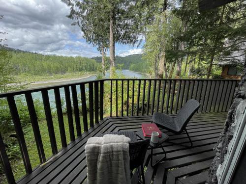 a deck with a table and chairs with a view of a river at Spacious North Cascades Riverside A-Frame with Mt Baker Views - Dog-Friendly in Concrete